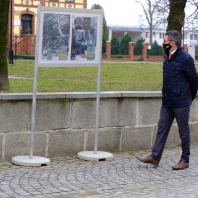 Zdjęcie przedstawiające Wójta Rafała Plezię oglądającego i czytającego wystawę